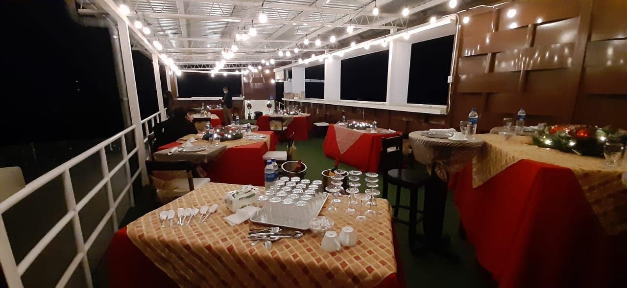 Montaje nocturno en terraza con mantelería roja y luces cálidas