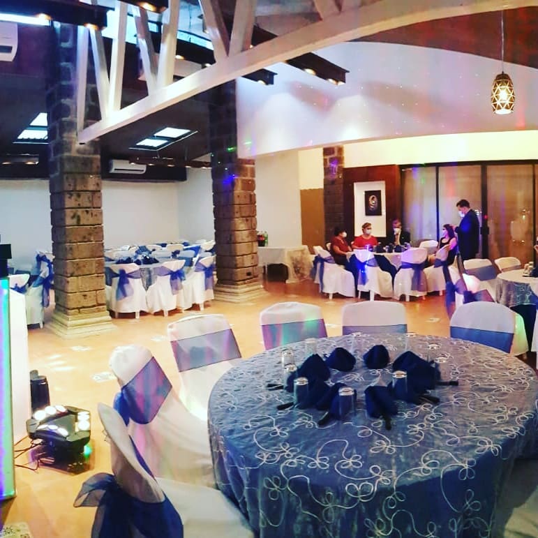 Salón con techo de vigas de madera montado en azul y plata