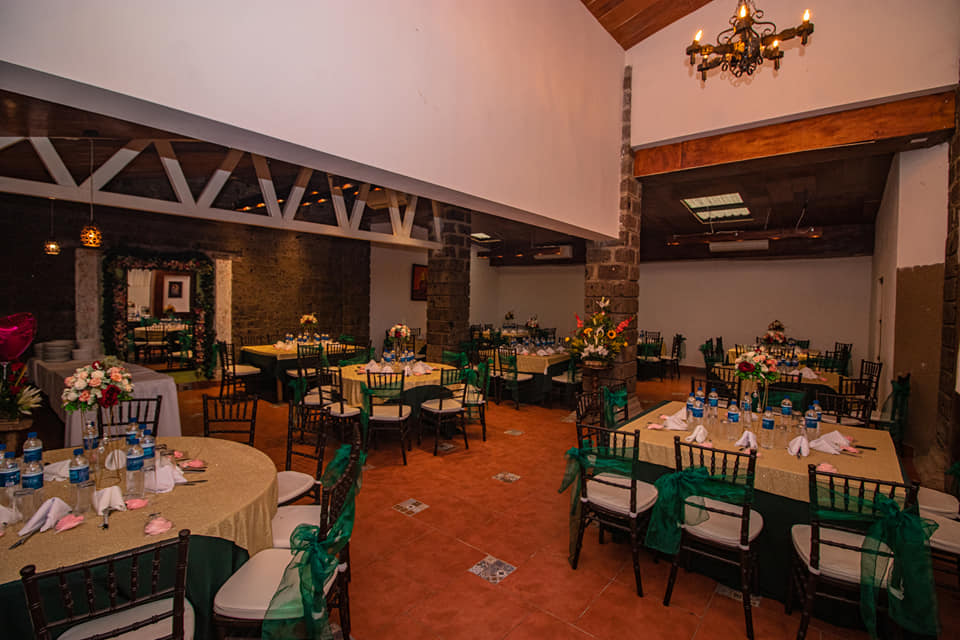 Salón rústico de El Patio montado en verde con candelabro de hierro forjado